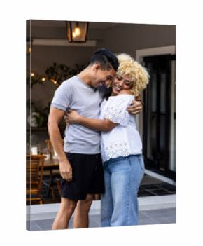 Embracing and laughing joyfully, couple on cozy patio enjoying their time