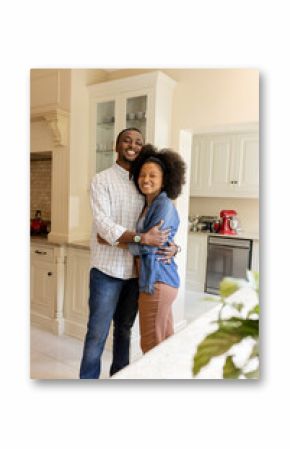 Embracing in kitchen, African American couple smiling, sharing quality time together