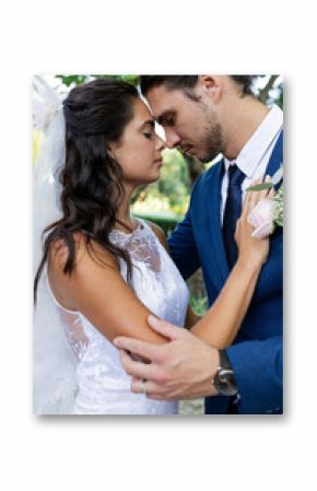 Bride and groom embracing tenderly outdoors, sharing romantic moment together