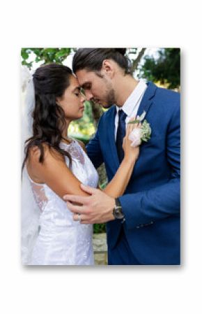 Bride and groom embracing tenderly in garden, sharing intimate moment on wedding day