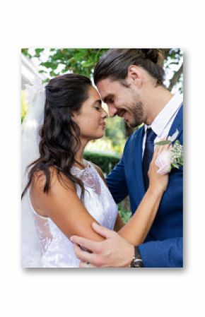 Bride and groom embracing outdoors, smiling and sharing joyful moment