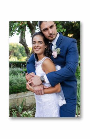 Bride and groom embracing in garden, smiling joyfully on wedding day