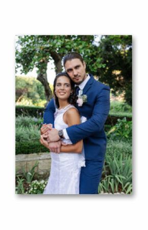 Bride and groom embracing in garden, celebrating love on wedding day