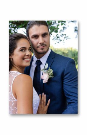 Bride and groom embracing outdoors, smiling joyfully on their wedding day
