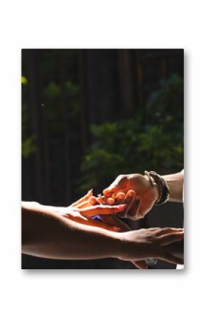 Couple holding hands outdoors, sunlight creating warm and intimate atmosphere, copy space
