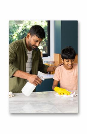 Cleaning kitchen counter, indian father and son working together, wearing yellow gloves