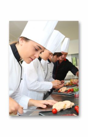 Team of young chefs preparing delicatessen dishes