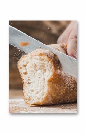 Whole grain bread put on kitchen wood plate with a chef holding gold knife for cut.