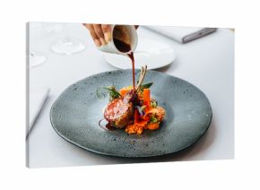 Modern French cuisine: Roasted Lamb neck & rack served with carrot, yellow curry pouring lamb sauce. Served in black stone plate