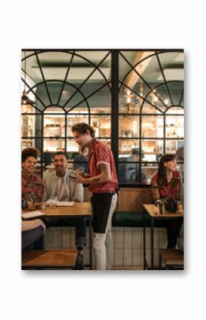 Waiter taking orders from customers sitting in a bistro