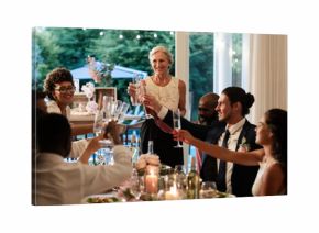 Guests raising glasses in joyful toast at elegant wedding reception dinner