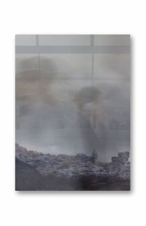 Merging rocky hilltop and blurred colleagues walking corridor, with city skyline behind stone cross
