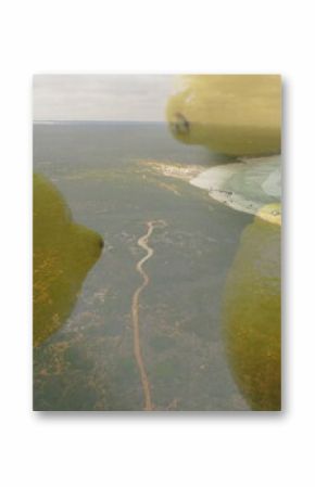 Hovering citrus-like spheres overlapping dirt path and beach, showing gentle ocean waves