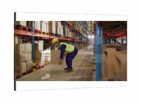 Bending knees Korean warehouse worker lifting cardboard box in aisle with helmet, vest, AR overlays