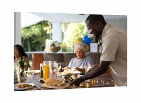 Serving fresh bread at family gathering, smiling and enjoying outdoor meal together