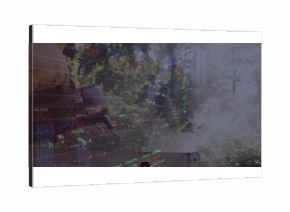 Grasping gloved hand holding tool on backyard grill, with smoke and financial charts, copy space