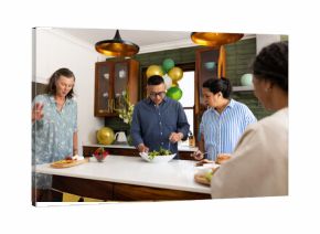Preparing healthy salad, seniors in modern kitchen having conversation together