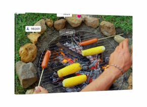 Friends roasting corn and hot dog skewers over backyard fire pit, with grill grate, glowing coals