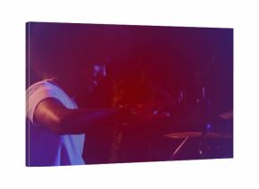 Playing Indian musician hitting snare and toms on stage with drumsticks and cymbals, copy space