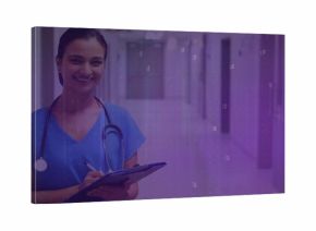 Smiling Indian nurse in scrubs using clipboard in hospital hallway, with stethoscope, copy space