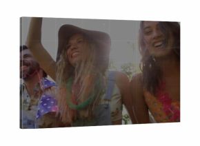 Standing five friends raising arms in sunlit park, with floral leis, lens flare and grid overlay