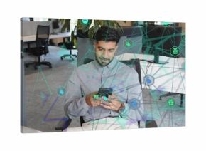 Tapping smartphone screen Indian professional sitting on chair in open-plan office, network overlay