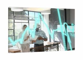 Discussing reports professionals in headscarf and shirt in office with holographic chart