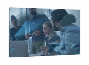 Meeting five colleagues in boardroom in business casual, viewing open laptop, papers, pen, AR clock