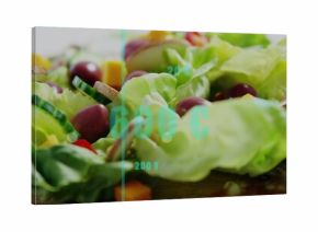 Displaying butter lettuce on wood board with cucumber dark olives cheddar salami under cyan overlay