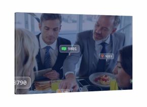 Discussing four execs wearing suits and tops sharing meal at glass lounge, holding tablet badges