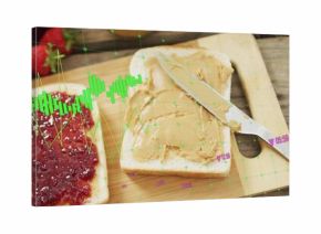 Showing bread slices sitting on cutting board bearing jam and peanut spread, knife, green overlay