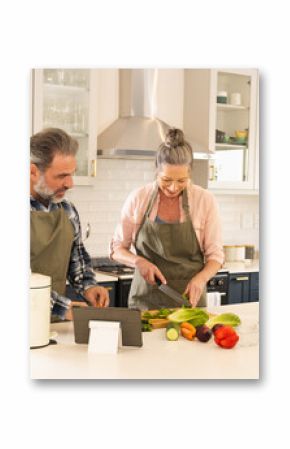 Preparing healthy meal in modern kitchen, mature couple smiling together, at home