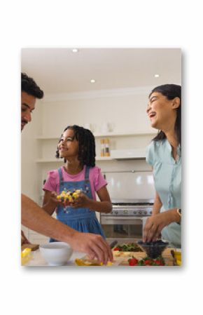 Family preparing healthy meal together in kitchen, smiling and enjoying time