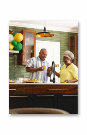 Preparing healthy meal, senior couple in modern kitchen, talking and smiling