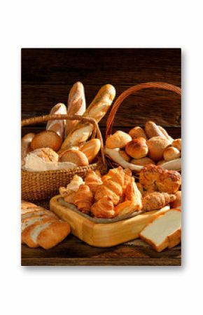 Variety of bread in wicker basket on old wooden background.