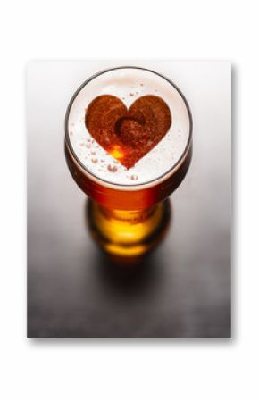 Loving beer concept. Heart symbol on beer glass foam on black table, view from above