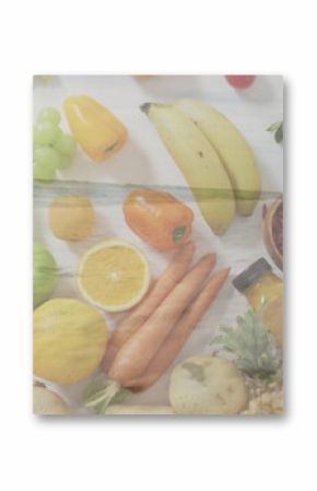 Displaying flat lay of fresh produce on light wood tabletop, with goji berries, pepper grinder