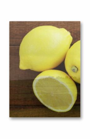 Displaying three bright yellow lemons resting on dark wooden tabletop, showing juicy interior pulp