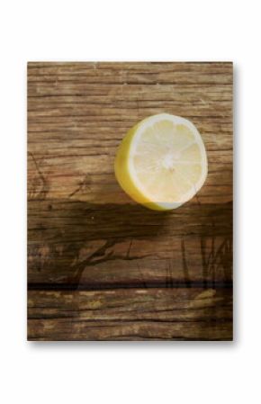 Displaying three yellow lemons resting on table planks under sunlit foliage shadows, copy space
