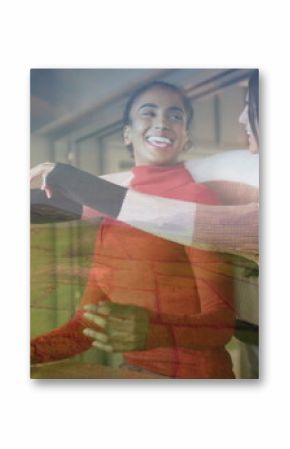 Spinning Middle Eastern teen and Indian woman in sweaters hugging in cafe lounge, with green apples