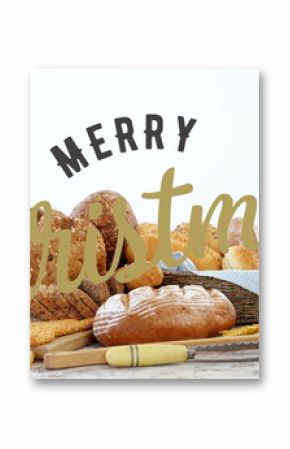 Bread assortment sitting on tabletop, with wicker basket, serrated knife, Merry Christmas lettering