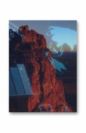 Rising rock formation in canyon at dusk with holographic globe and bar chart on circuit grid