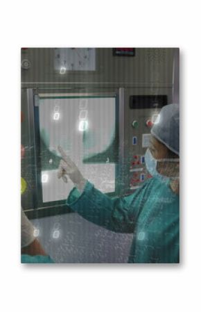 Pointing surgeon highlighting radiograph on X-ray screen at control panel, with dials and clock