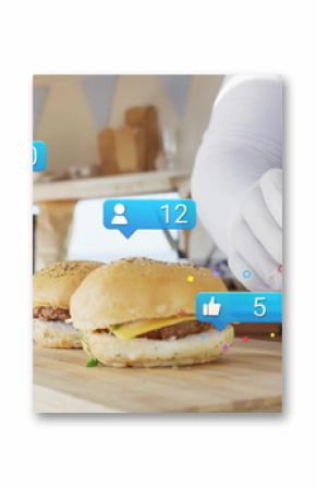 Vendor in striped apron placing items in box at food truck, with cheeseburgers board social icons