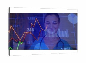 Smiling Indian nurse in blue scrubs and stethoscope analyzing financial data in studio, with charts