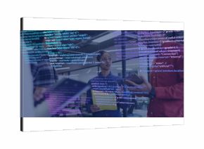 Holding tablet denim-jacketed engineer listening in open office, with code overlay and monitors
