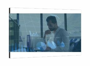 Reviewing data middle eastern professional analyzing charts at modern office with laptop and binder