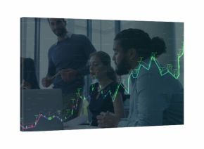 Collaborating business team analyzing financial chart on laptop in glass meeting room, with reports