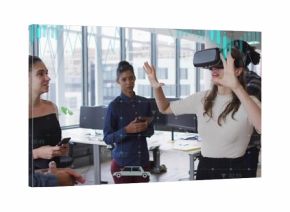 Demonstrating woman wearing VR headset gesturing forward in office, with smartphone and tablet