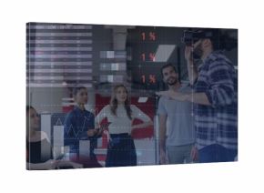 Gesturing Middle Eastern man with VR headset presenting charts in open-plan office, copy space